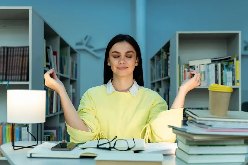Mujer practicando meditación en su lugar de trabajo para mejorar su productividad laboral